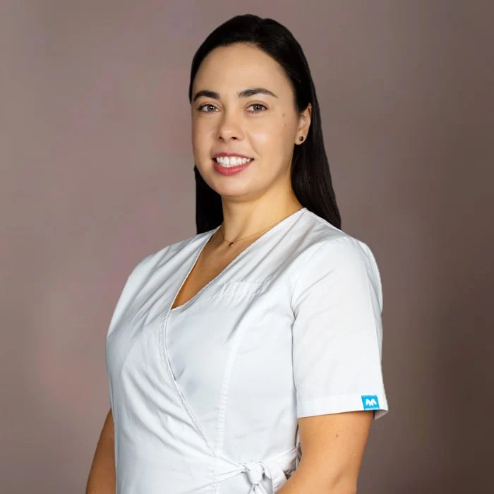 Medic stomatolog endodontist Dr. Socolova Aliona realizând tratamente de canal la microscop și restaurări dentare estetice